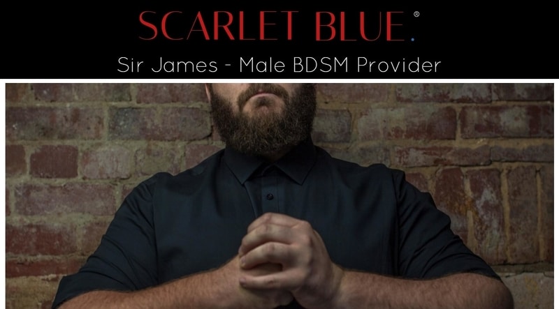 a male BDSM provider sitting by a brick wall 