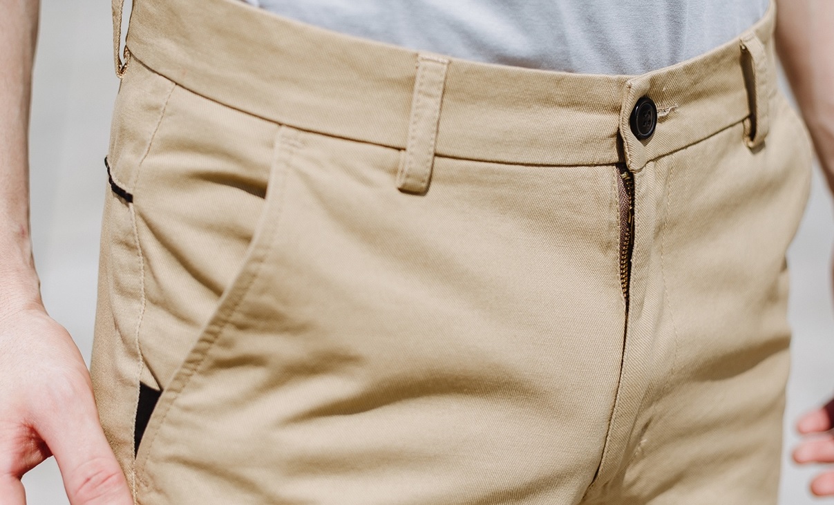 man wearing tan chinos showing where his male chastity device is